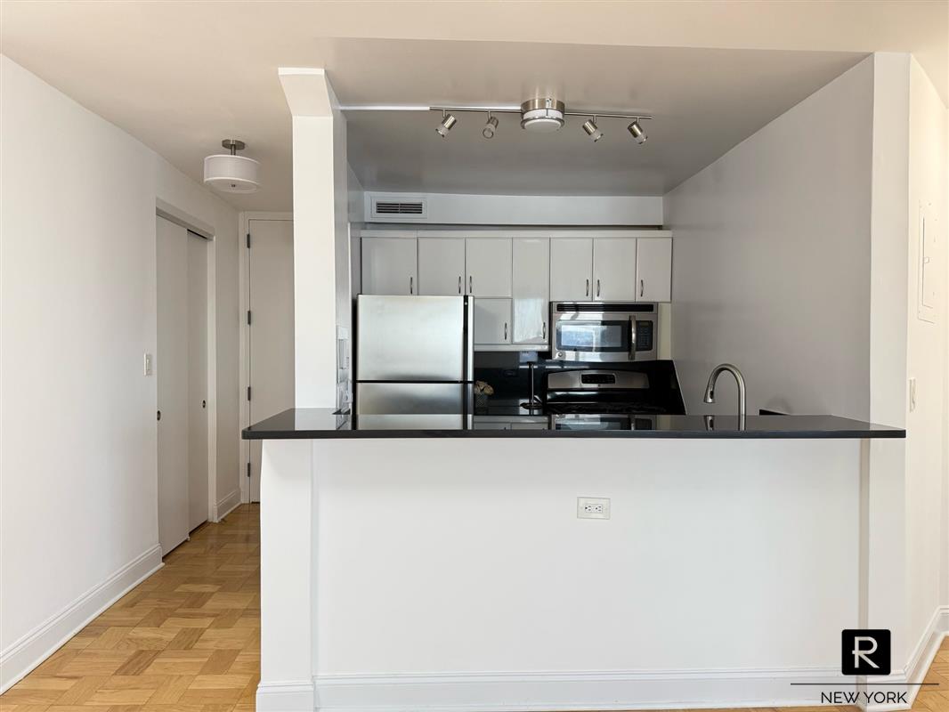 a large kitchen with a refrigerator and a sink