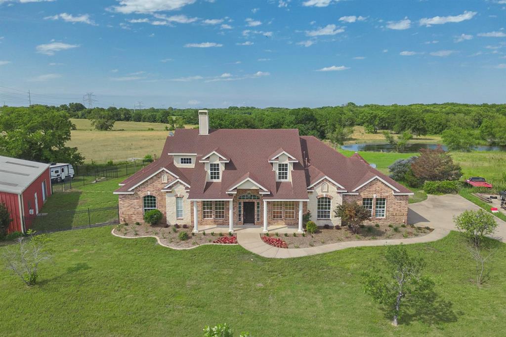 a aerial view of a house with a big yard and large trees