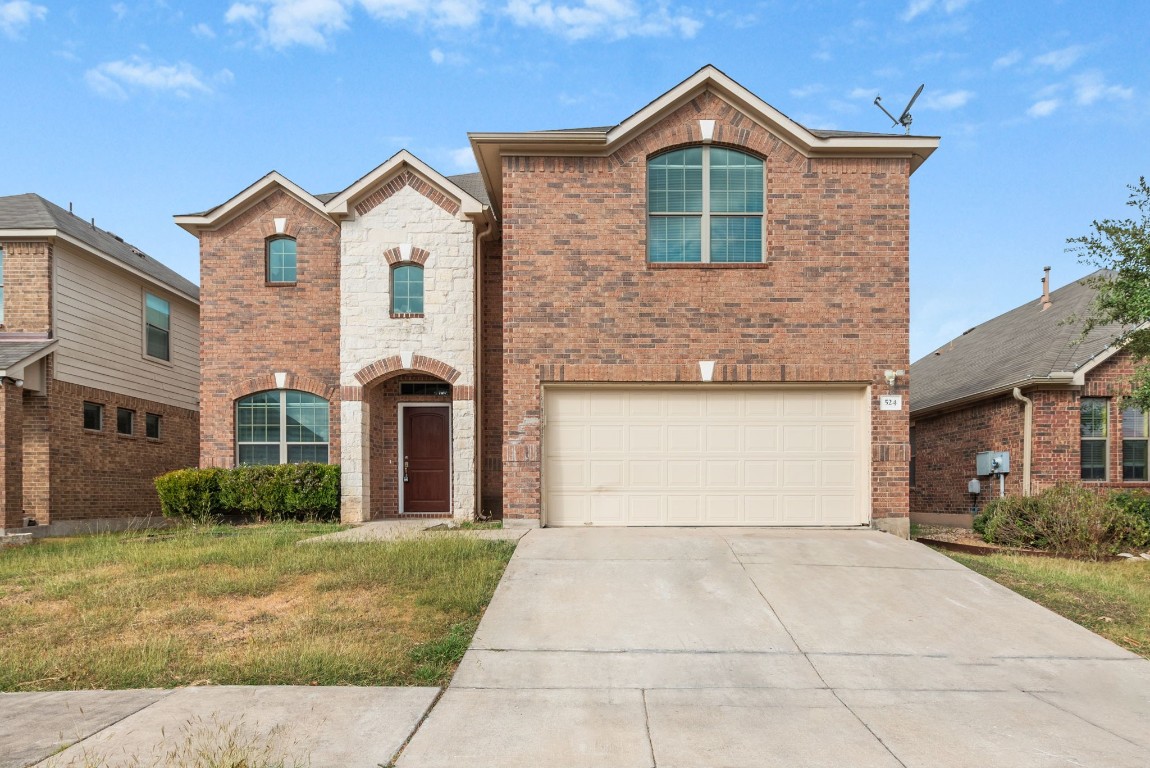 a front view of a house with a yard and garage