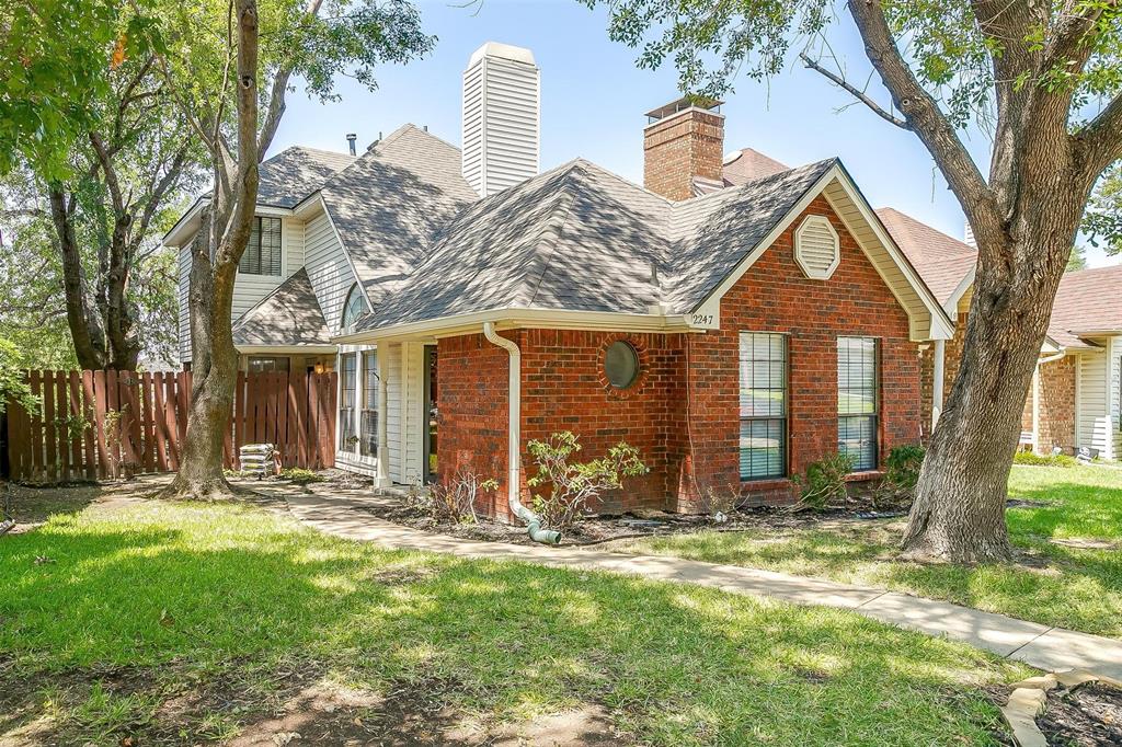 front view of a house with a large tree and a big yard