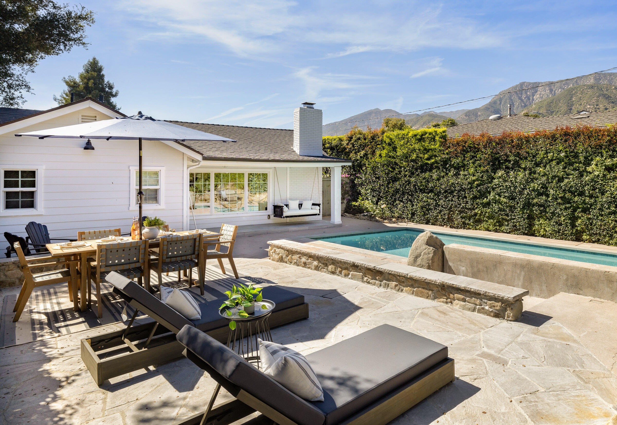 a view of a patio with couches table and chairs with wooden floor and fence