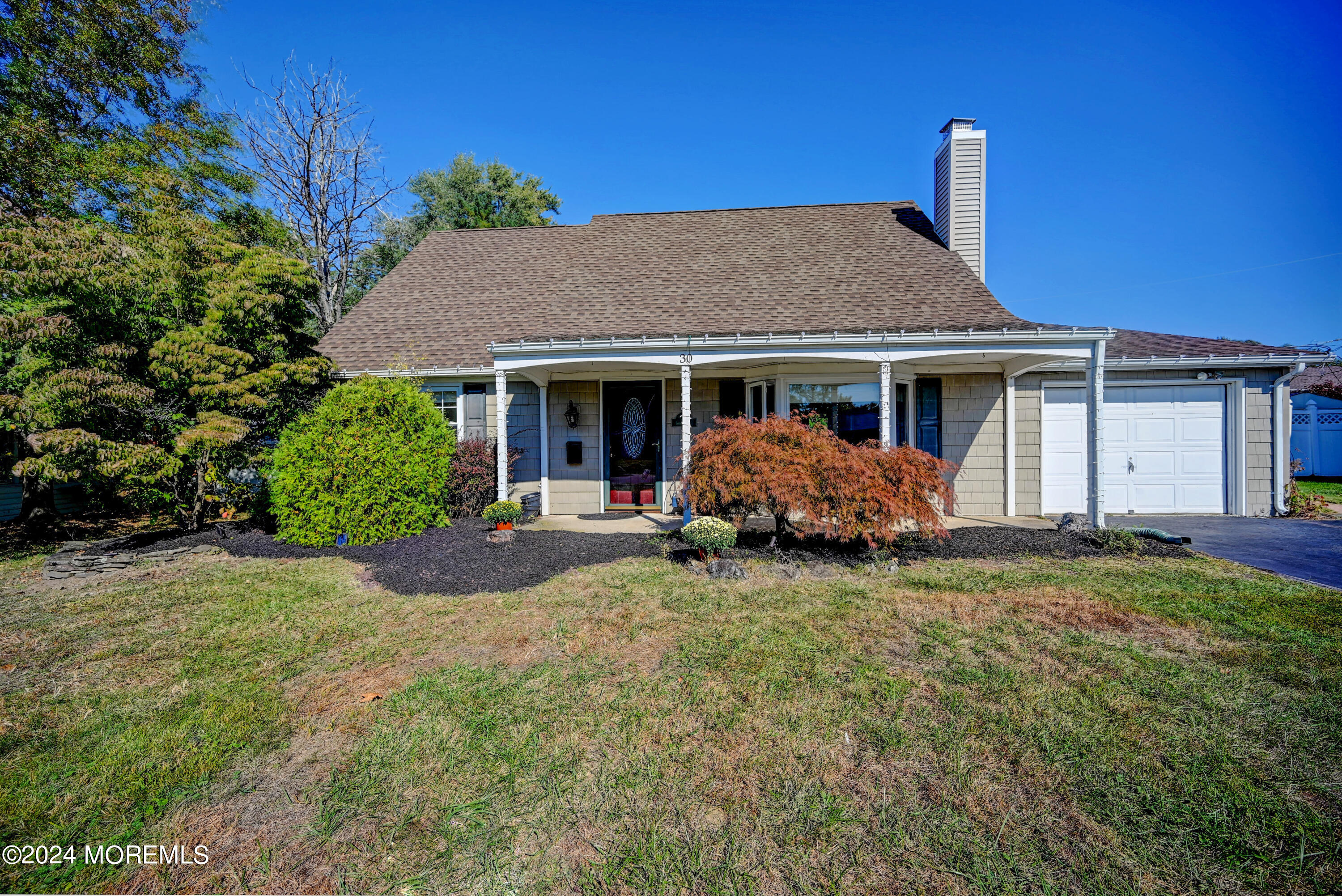 a view of a house with a yard and large tree