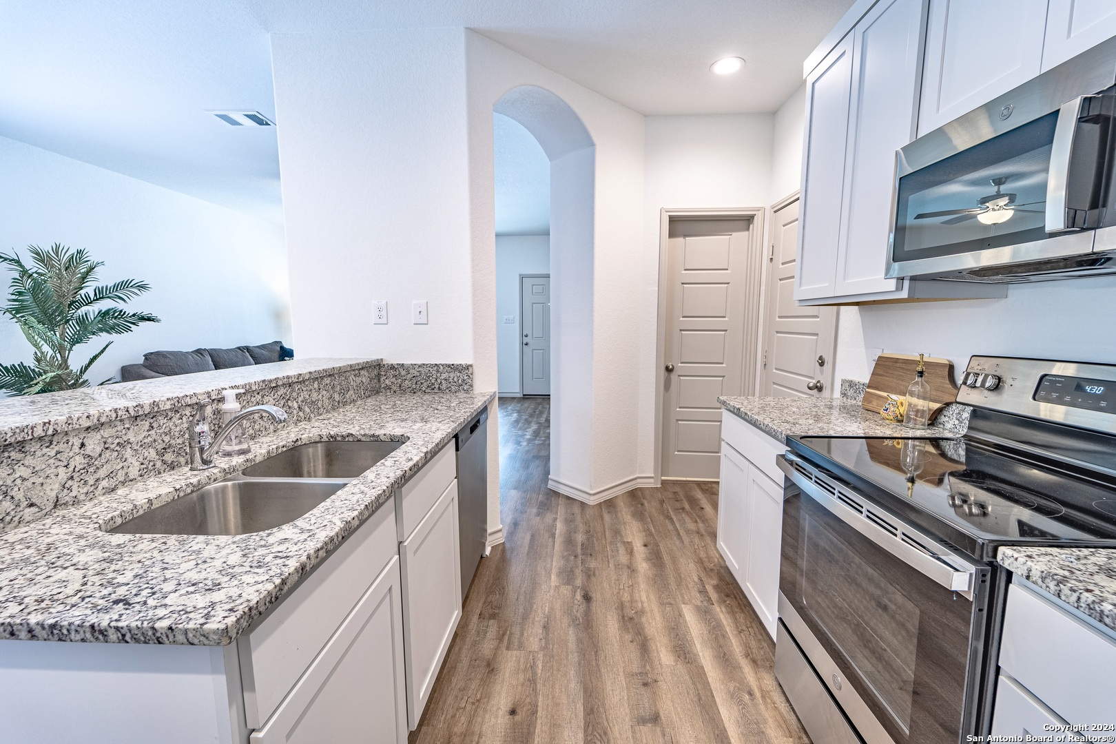 a kitchen with kitchen island granite countertop a sink stove and refrigerator