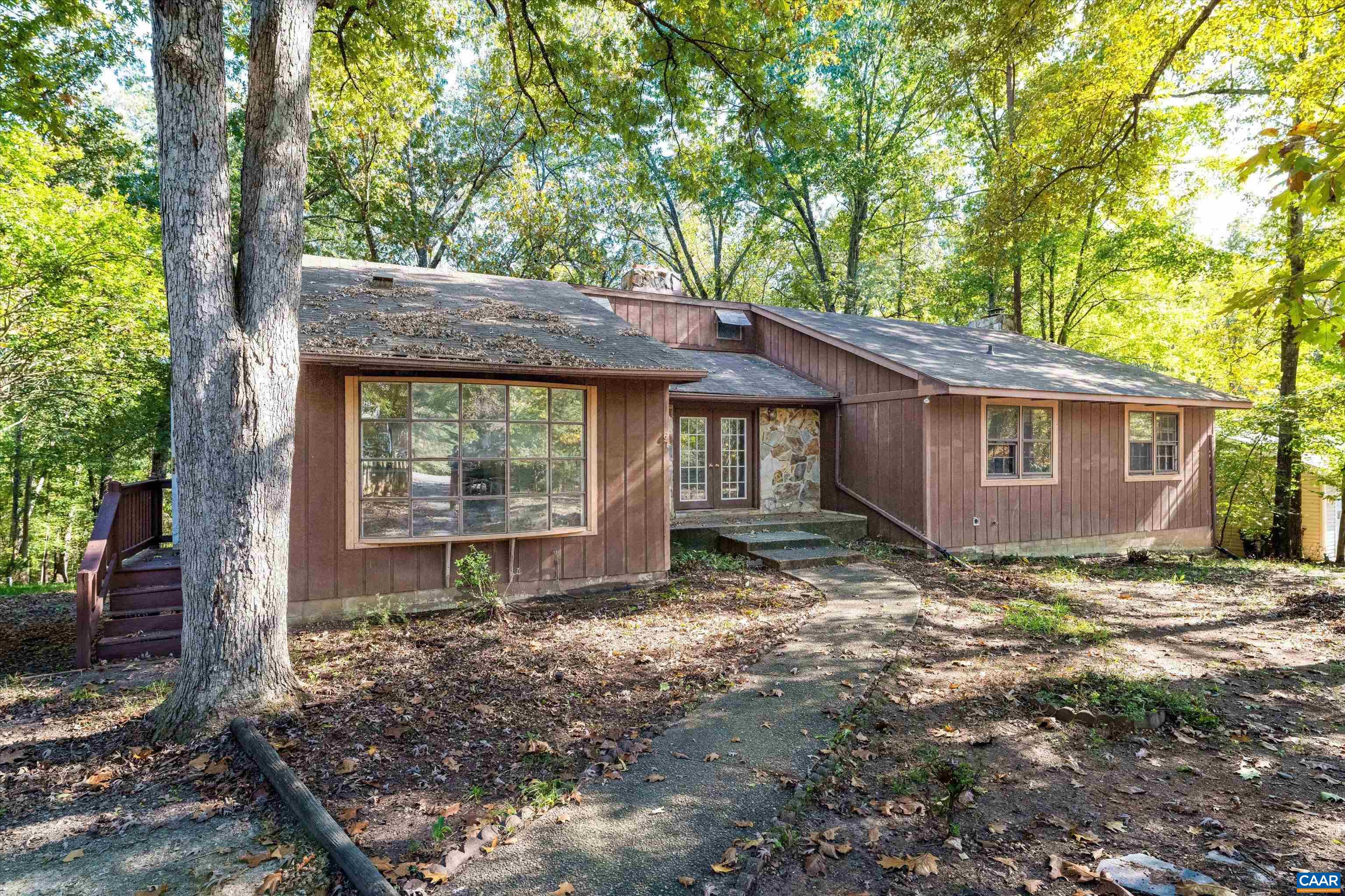 a view of a house with a yard and large tree