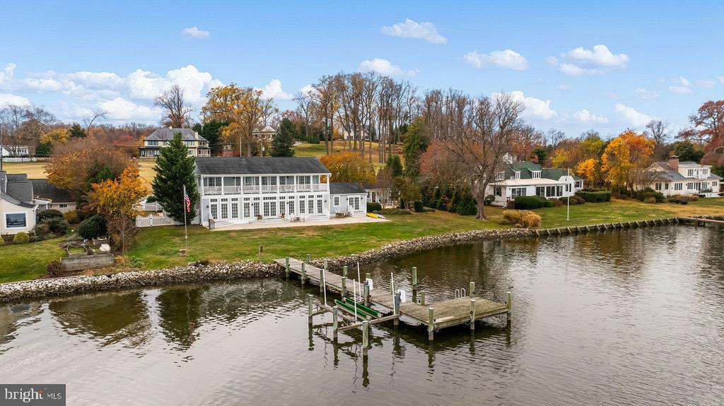 a view of a lake with a yard and wooden fence