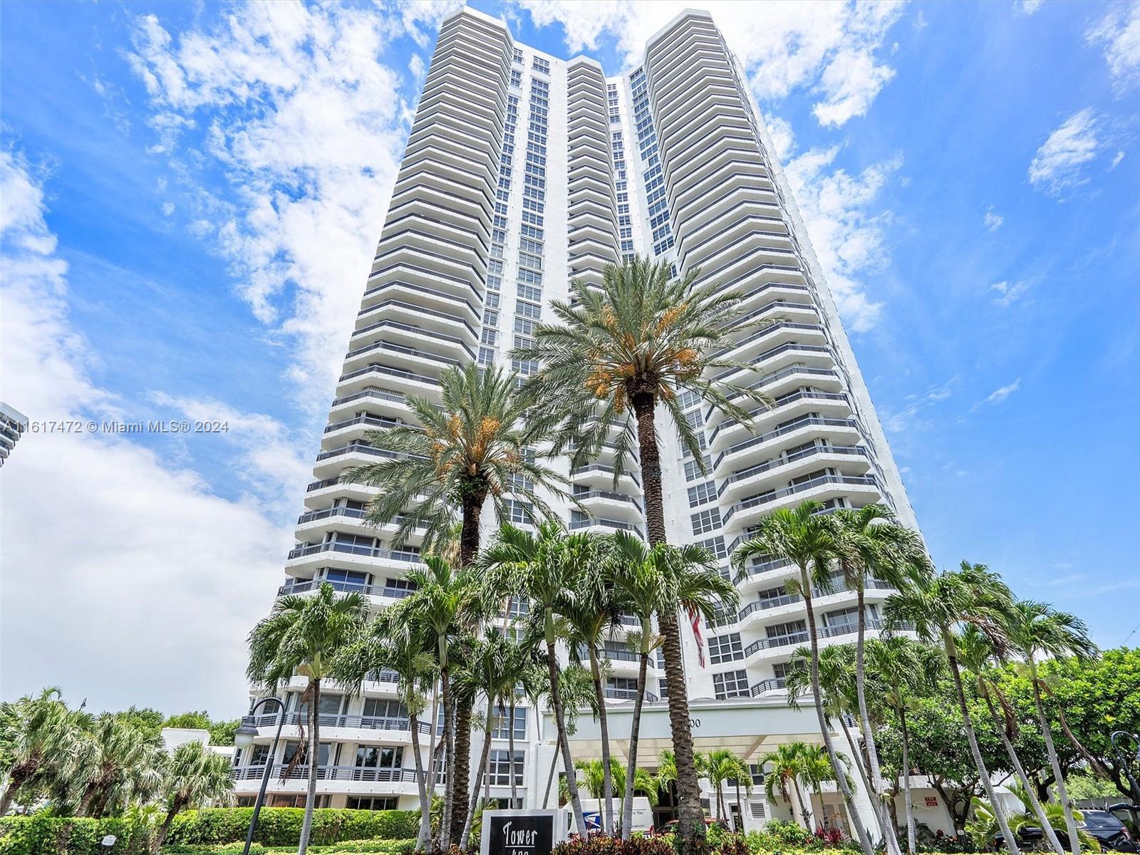 a view of a tall building with a palm tree in the background