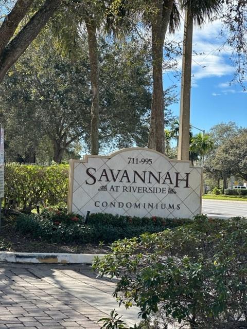 a view of a street sign under a large tree