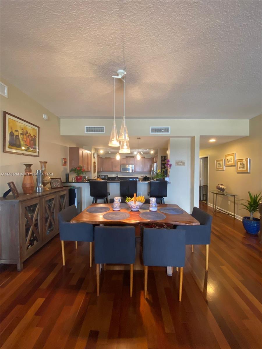 a dining room with furniture a chandelier and wooden floor