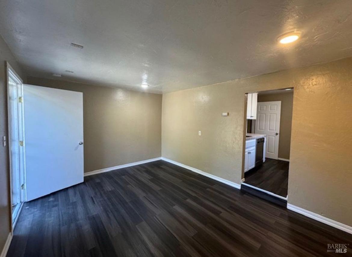 a view of an empty room and wooden floor