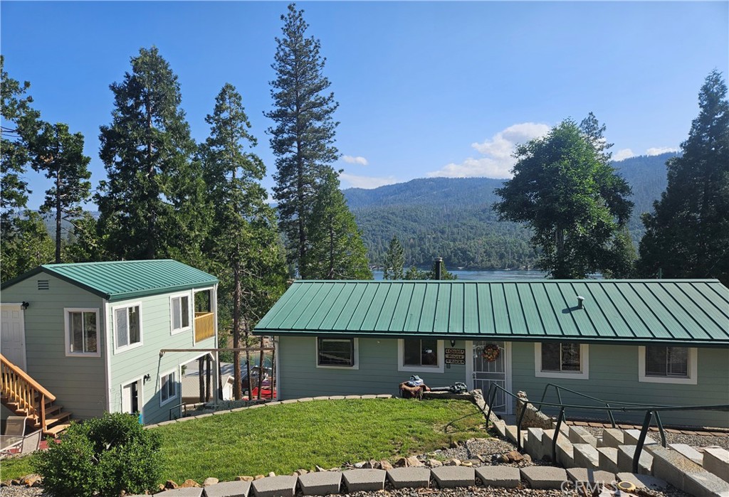 a view of a big house with a big yard and large tree