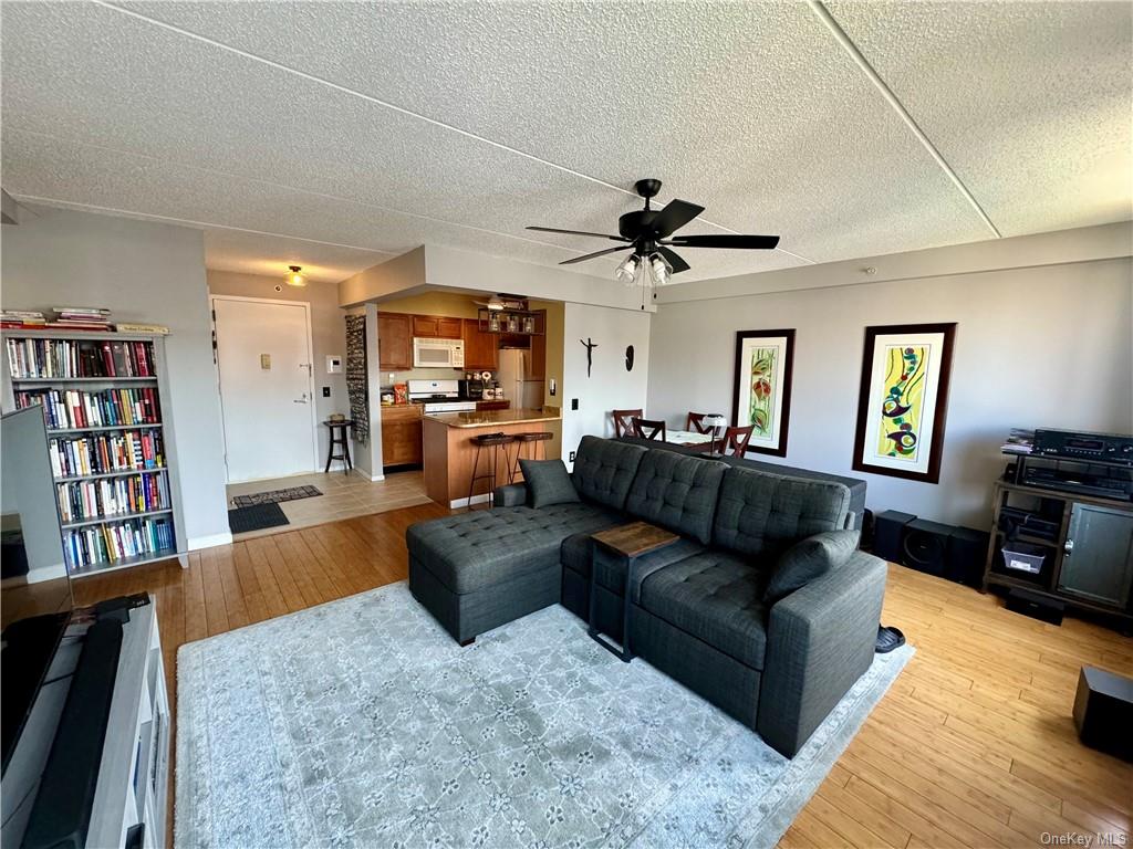 a living room with furniture kitchen view and a flat screen tv