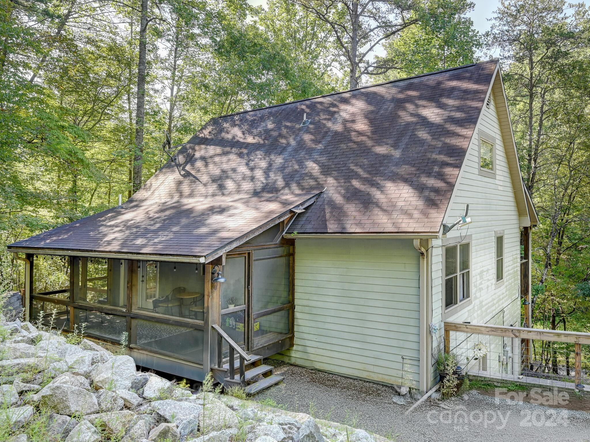 a view of a house with a yard chairs and wooden fence