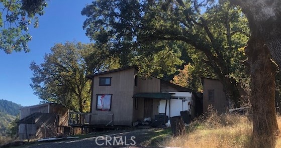 a front view of a house with a tree