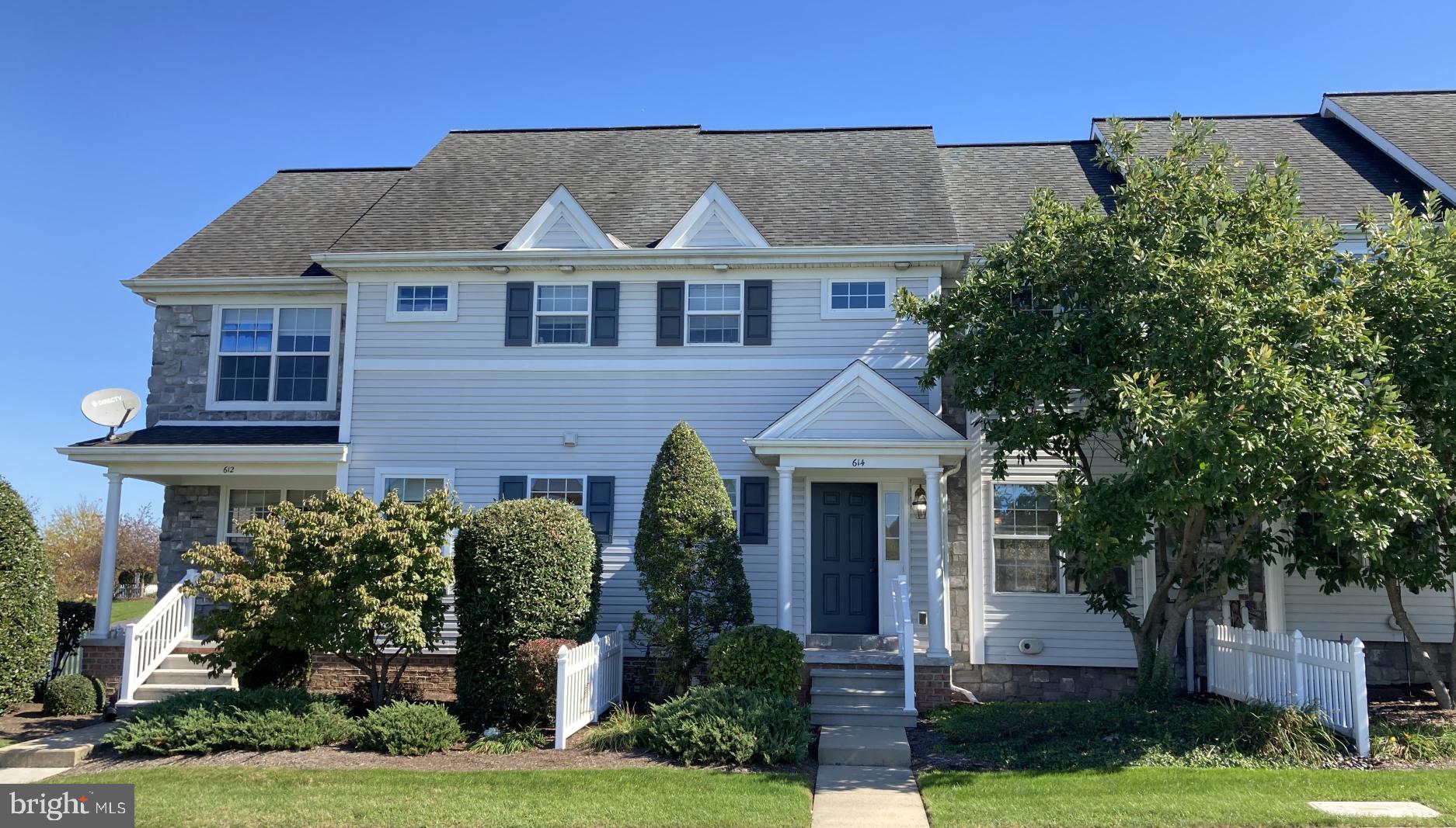 a front view of a house with a yard and potted plants