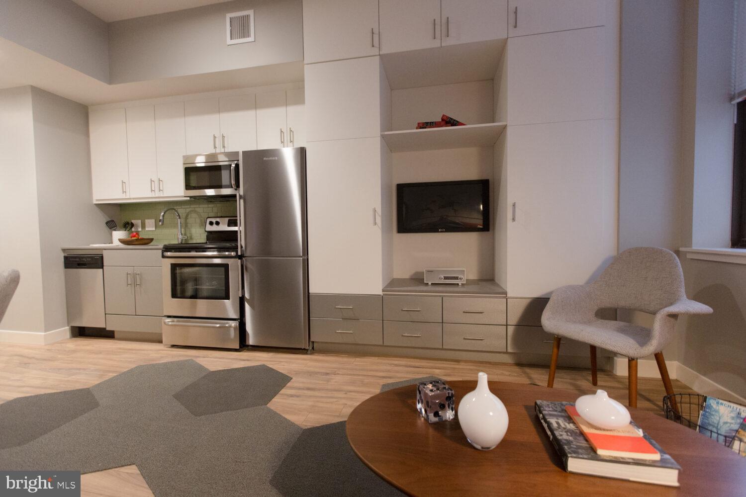 a kitchen with stainless steel appliances a stove a refrigerator and a fireplace