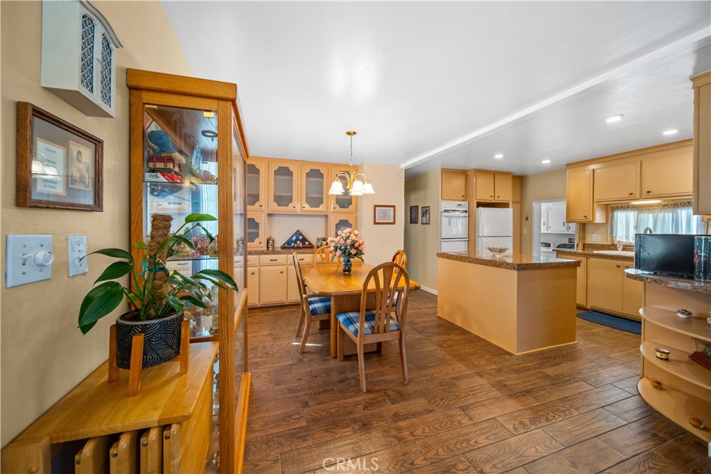 a dining room filled chandelier and wooden floor