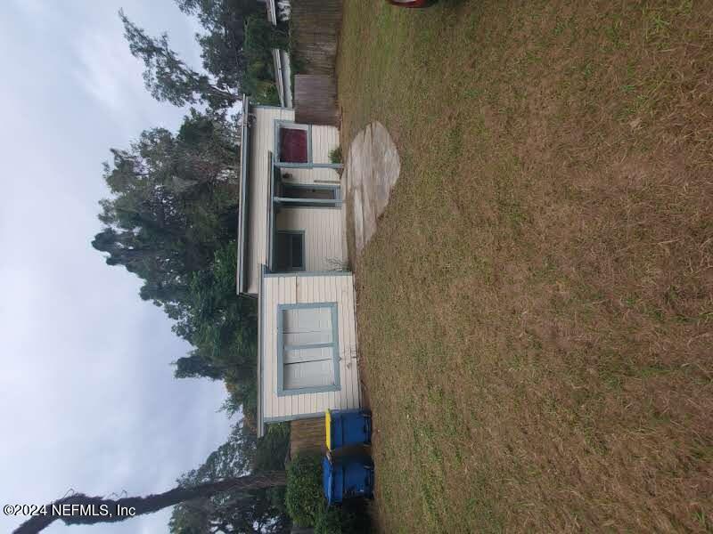 front view of house with yard and trees in the background