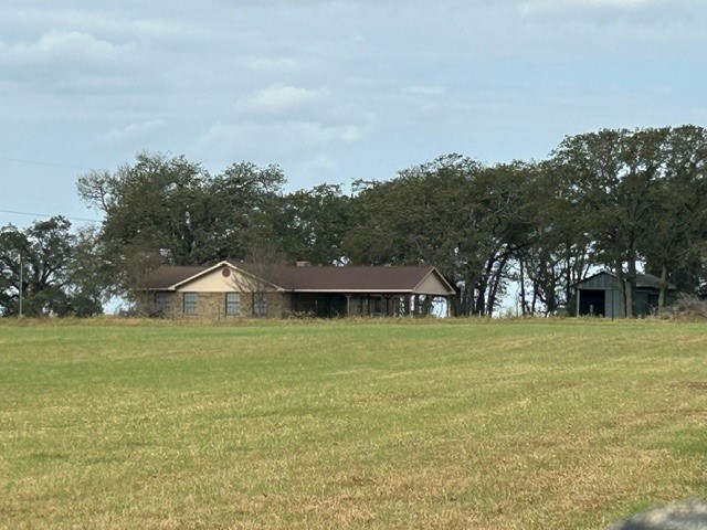 a front view of a house with a yard and trees