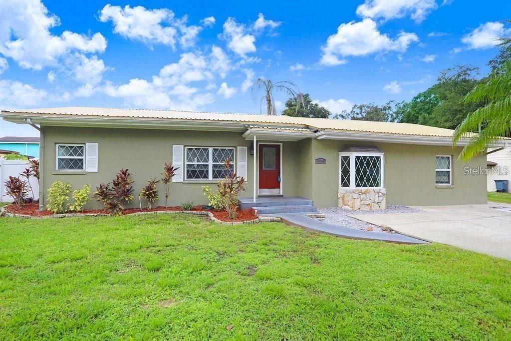 a front view of house with a garden and patio