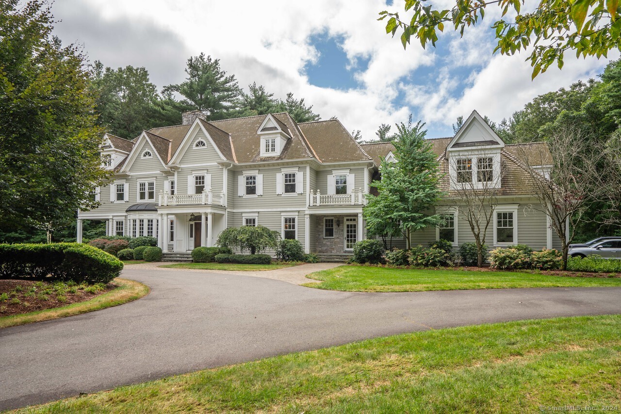 a front view of a house with a yard and trees