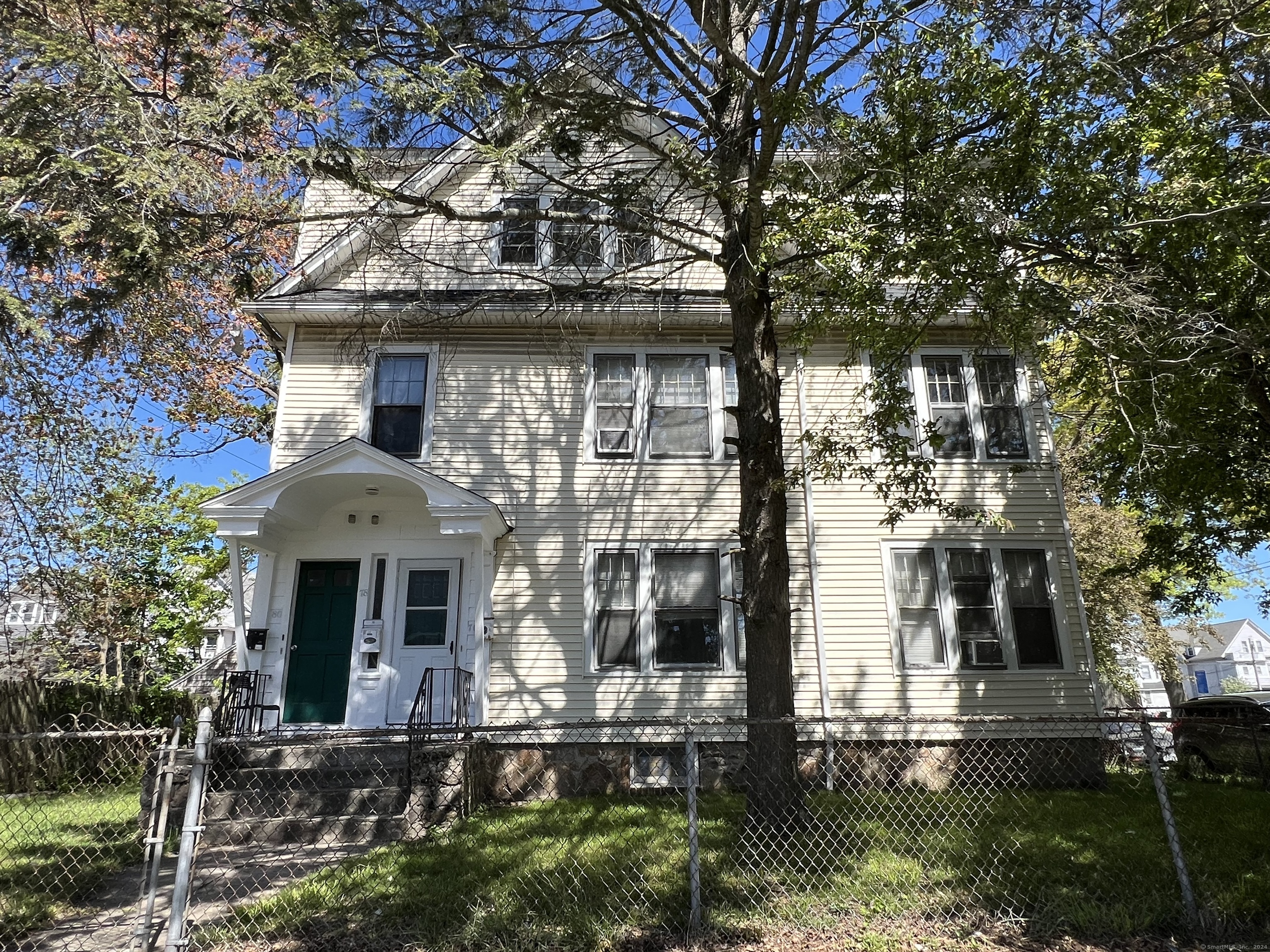 front view of house with a tree in front