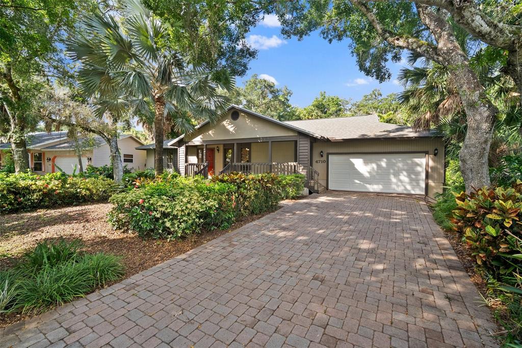 a front view of a house with a yard and potted plants