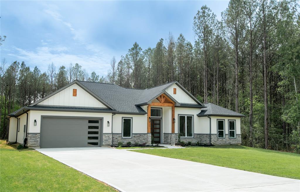 a front view of a house with a garden and trees