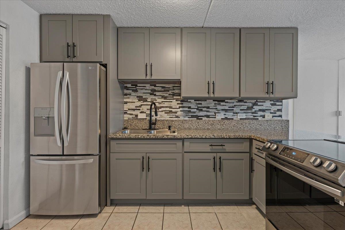 a kitchen with stainless steel appliances granite countertop a refrigerator sink and stove