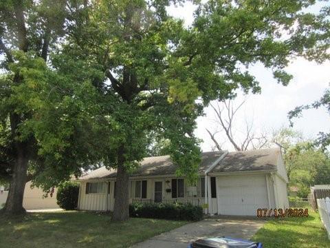 a front view of a house with a garden and trees