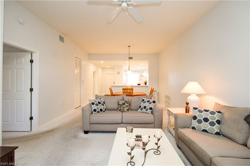 Carpeted living room with ceiling fan