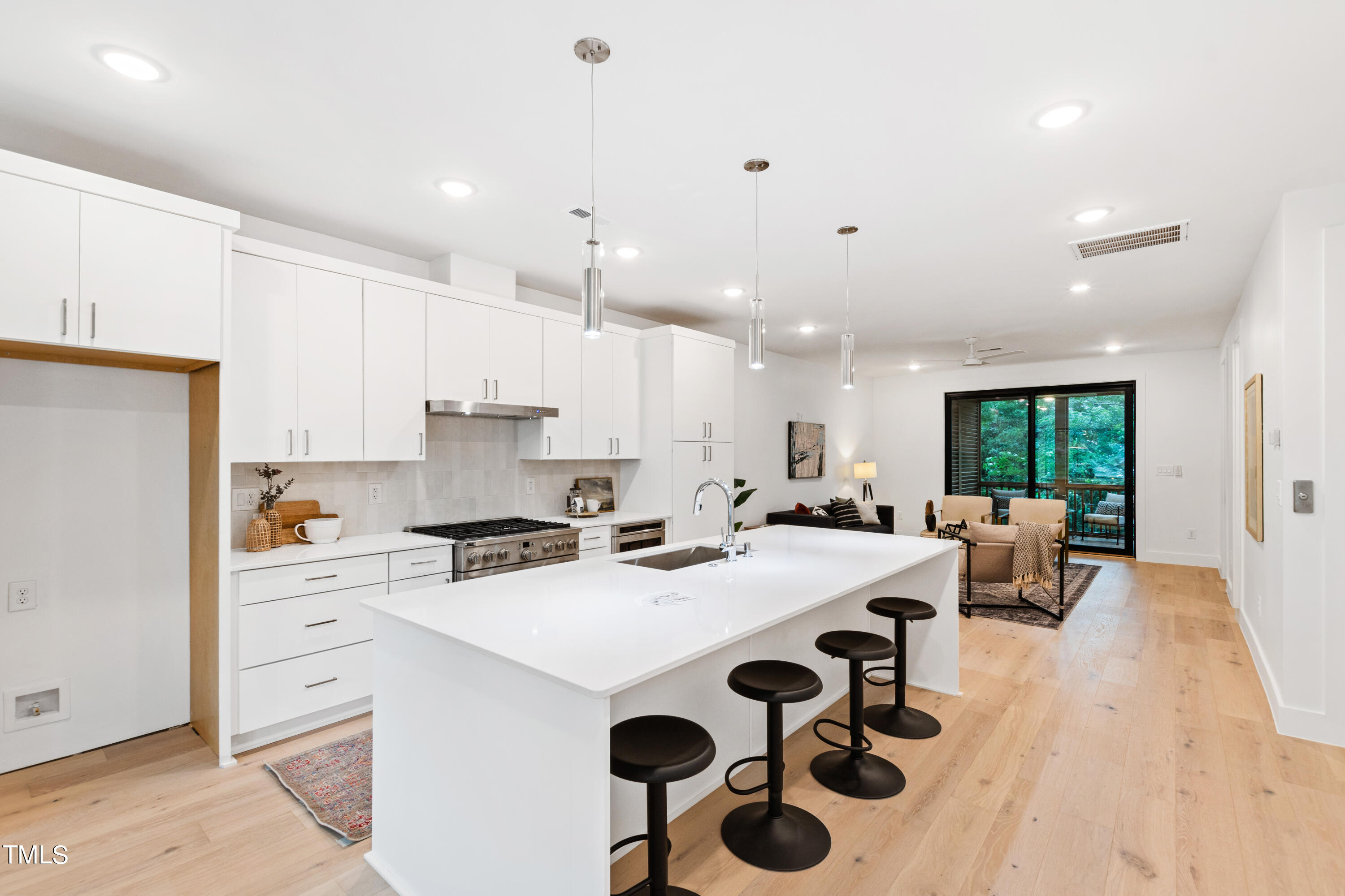 a kitchen with a sink a stove a refrigerator and white cabinets