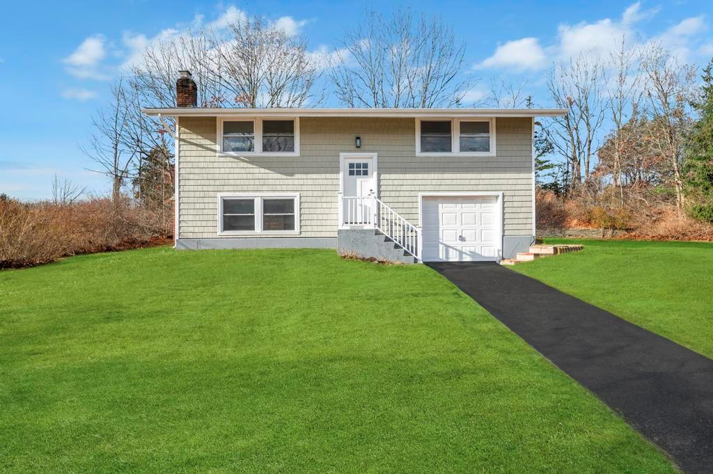 a front view of a house with a yard and garage