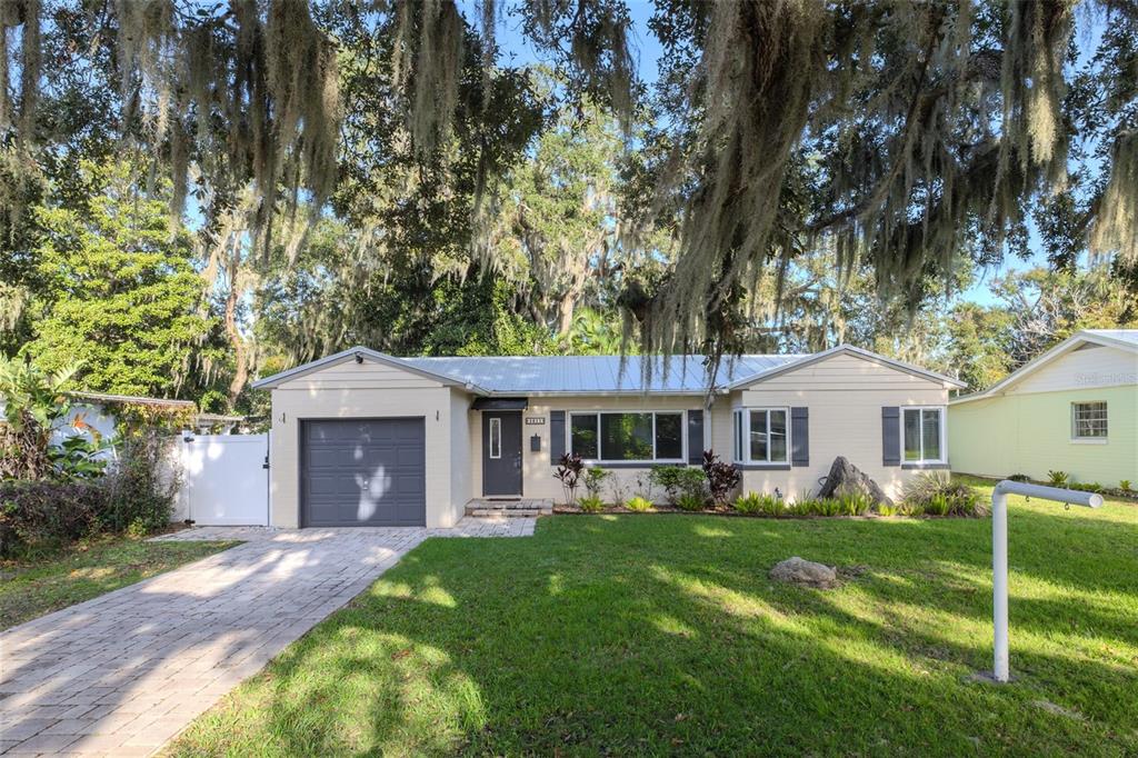 a front view of a house with a yard and trees