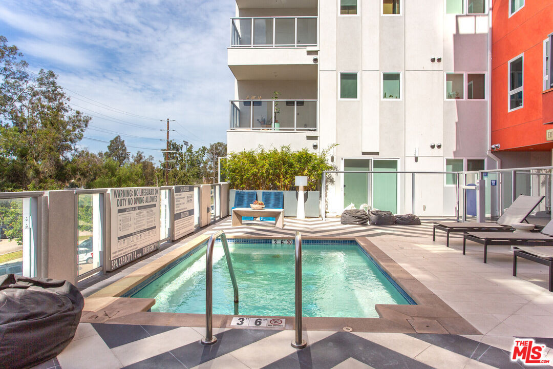 a view of a house with pool and chairs