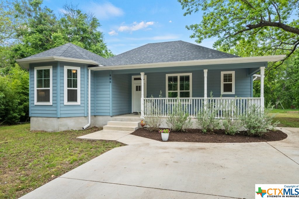 a front view of a house with a garden and plants