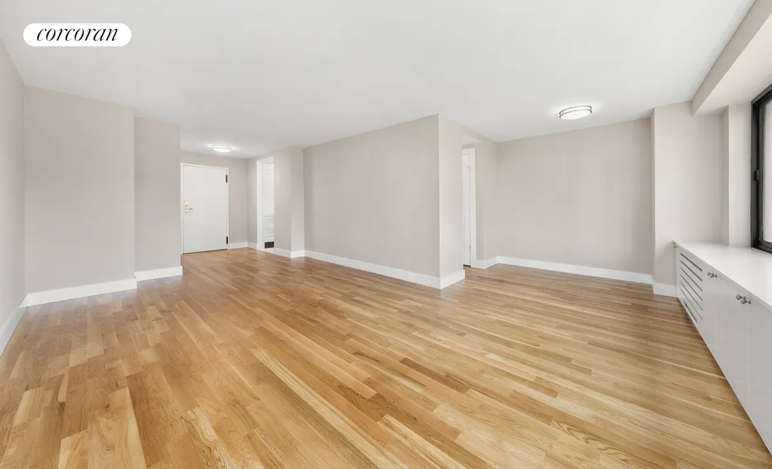 a view of empty room with wooden floor