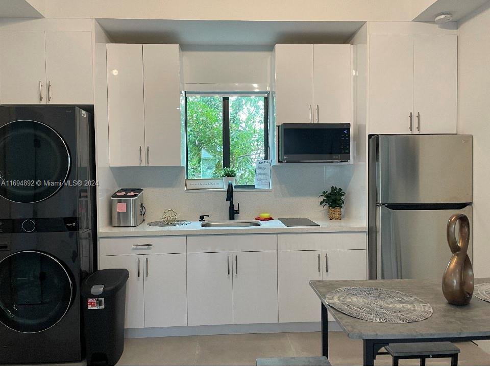 a kitchen with a sink a refrigerator and cabinets