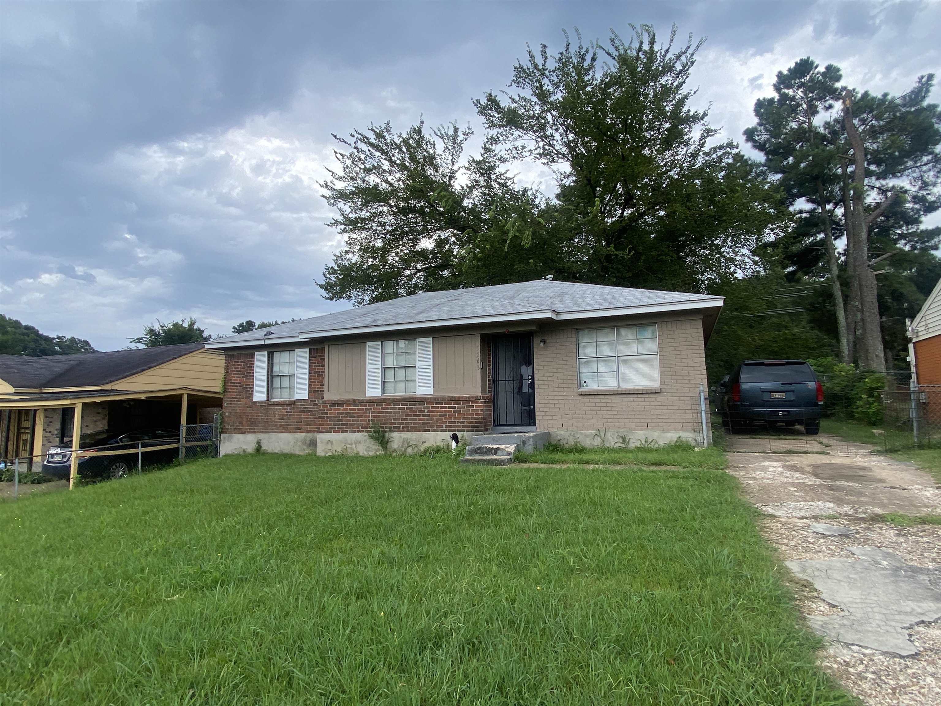 a front view of a house with a yard and trees