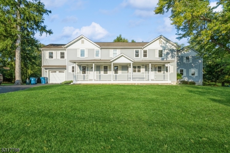 a front view of a house with a garden and trees