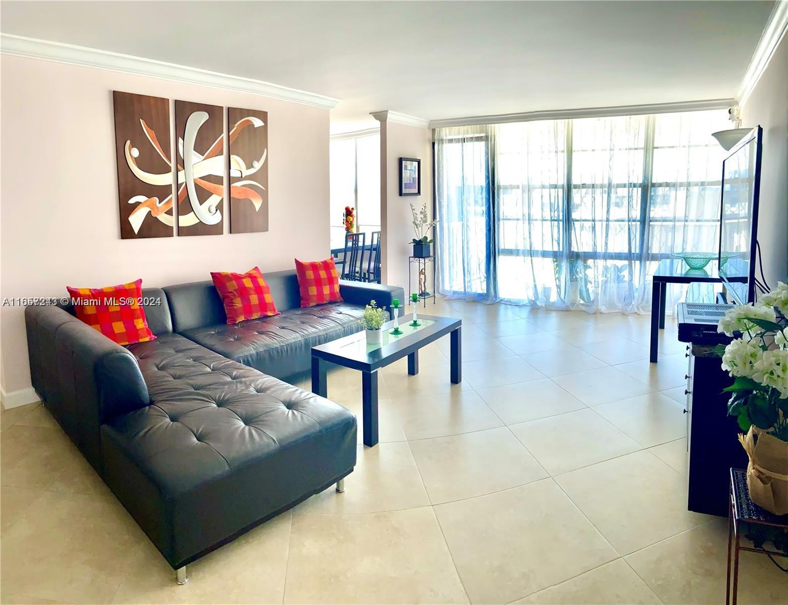 a living room with furniture and floor to ceiling window