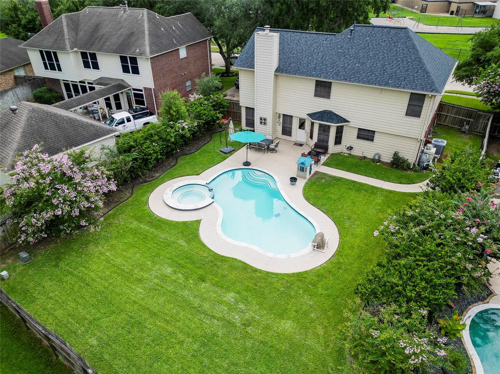 an aerial view of a house with swimming pool and patio