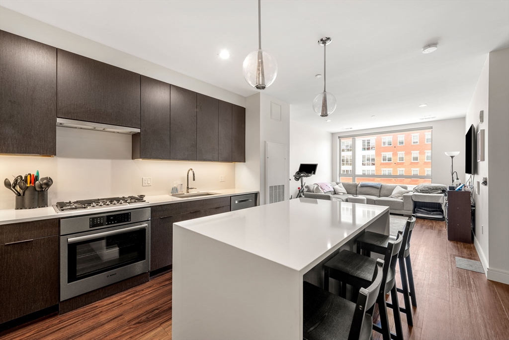 a kitchen with a stove a sink and chairs