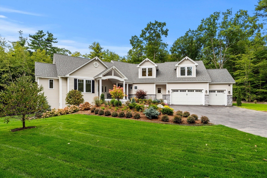 a front view of a house with a garden and trees