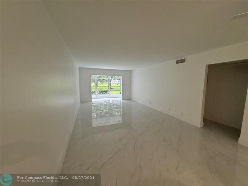 a view of an empty room and a window