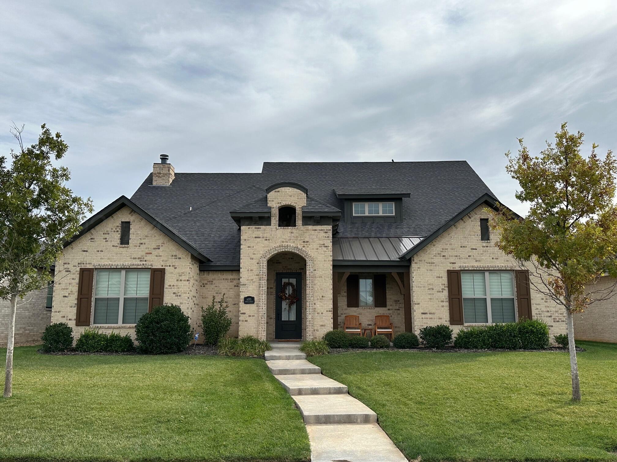 a front view of a house with a garden