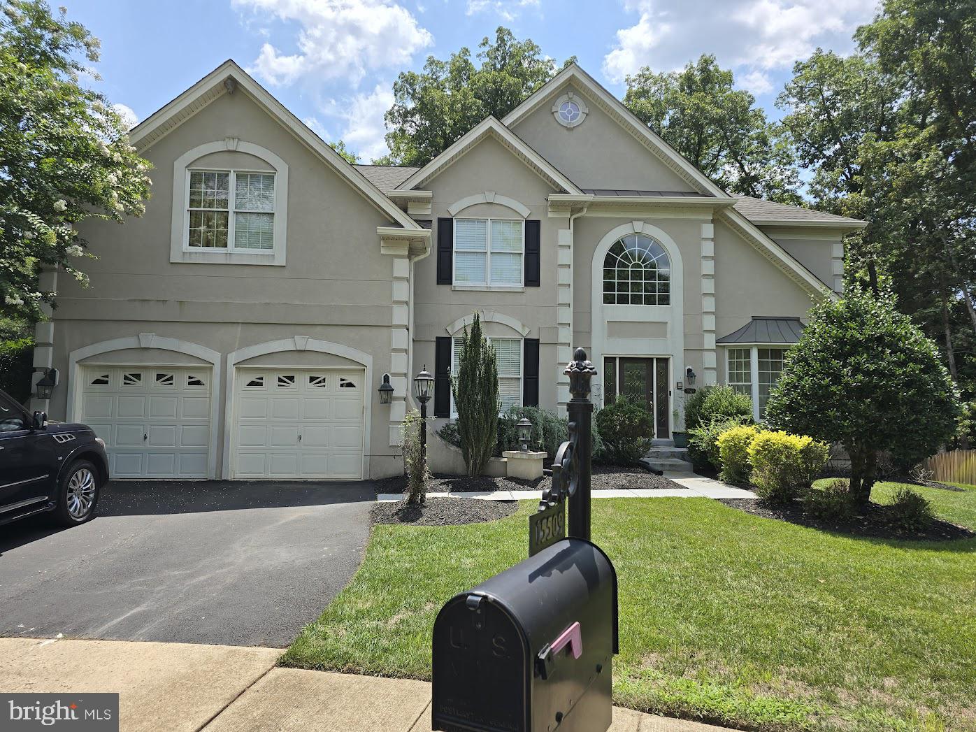 a front view of a house with a yard and trees