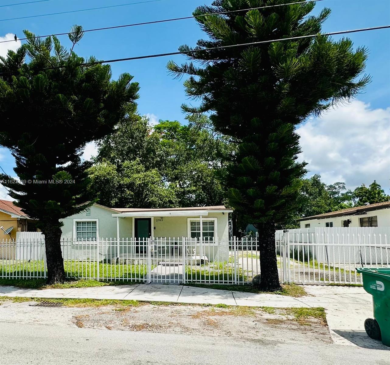 a front view of a house with a garden and plants