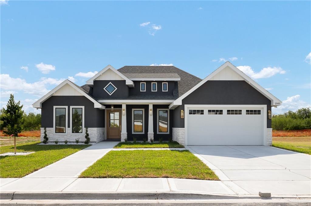 Craftsman inspired home with a front lawn and a garage