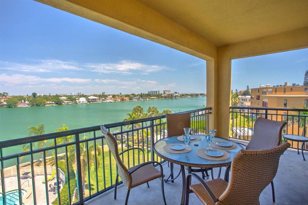 a view of a city from a chairs and table in the balcony