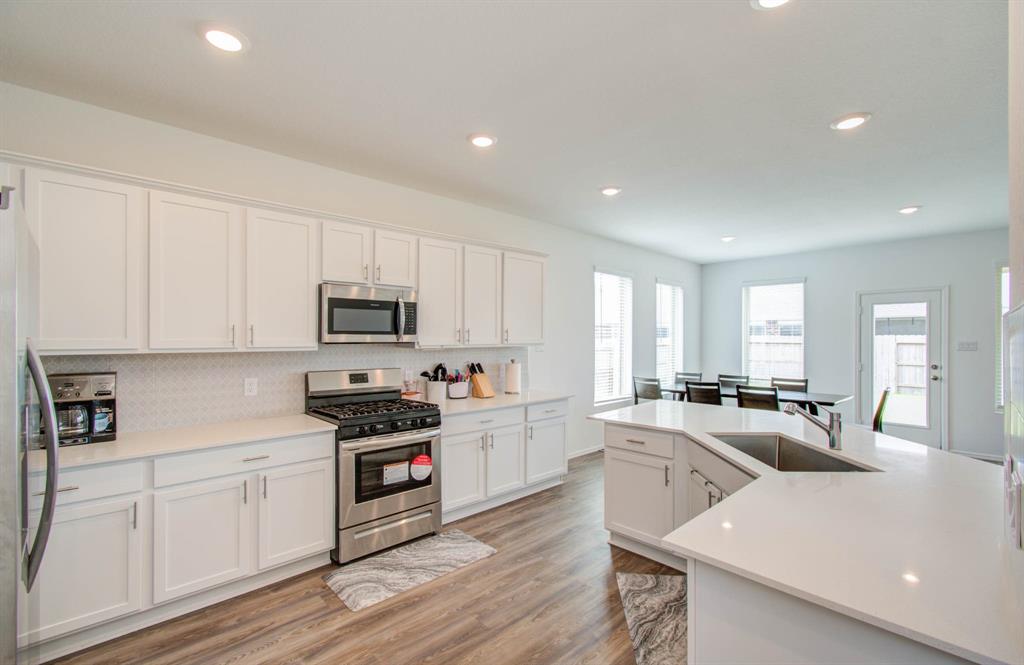 a kitchen with white cabinets and appliances